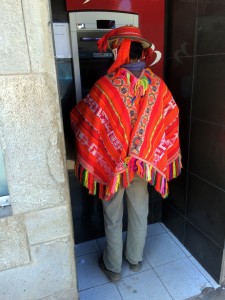 Quechua speaker in traditional garb using ATM
